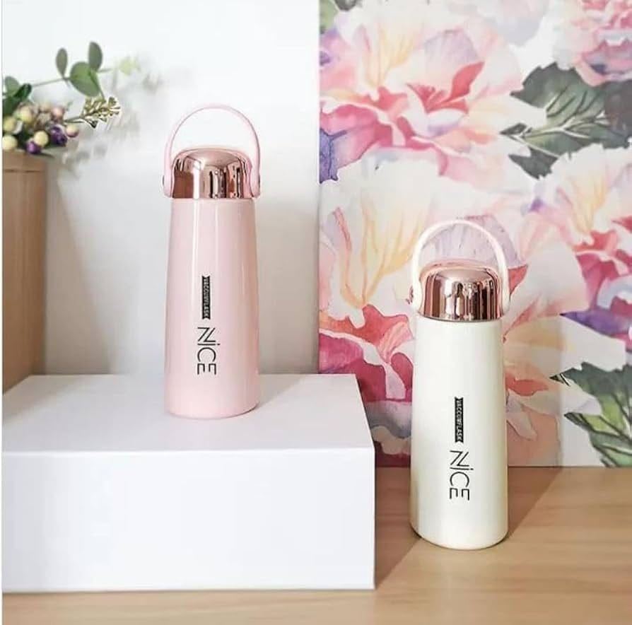 Two pink and white thermos bottles with 'NICE' branding on a wooden surface with a floral background.