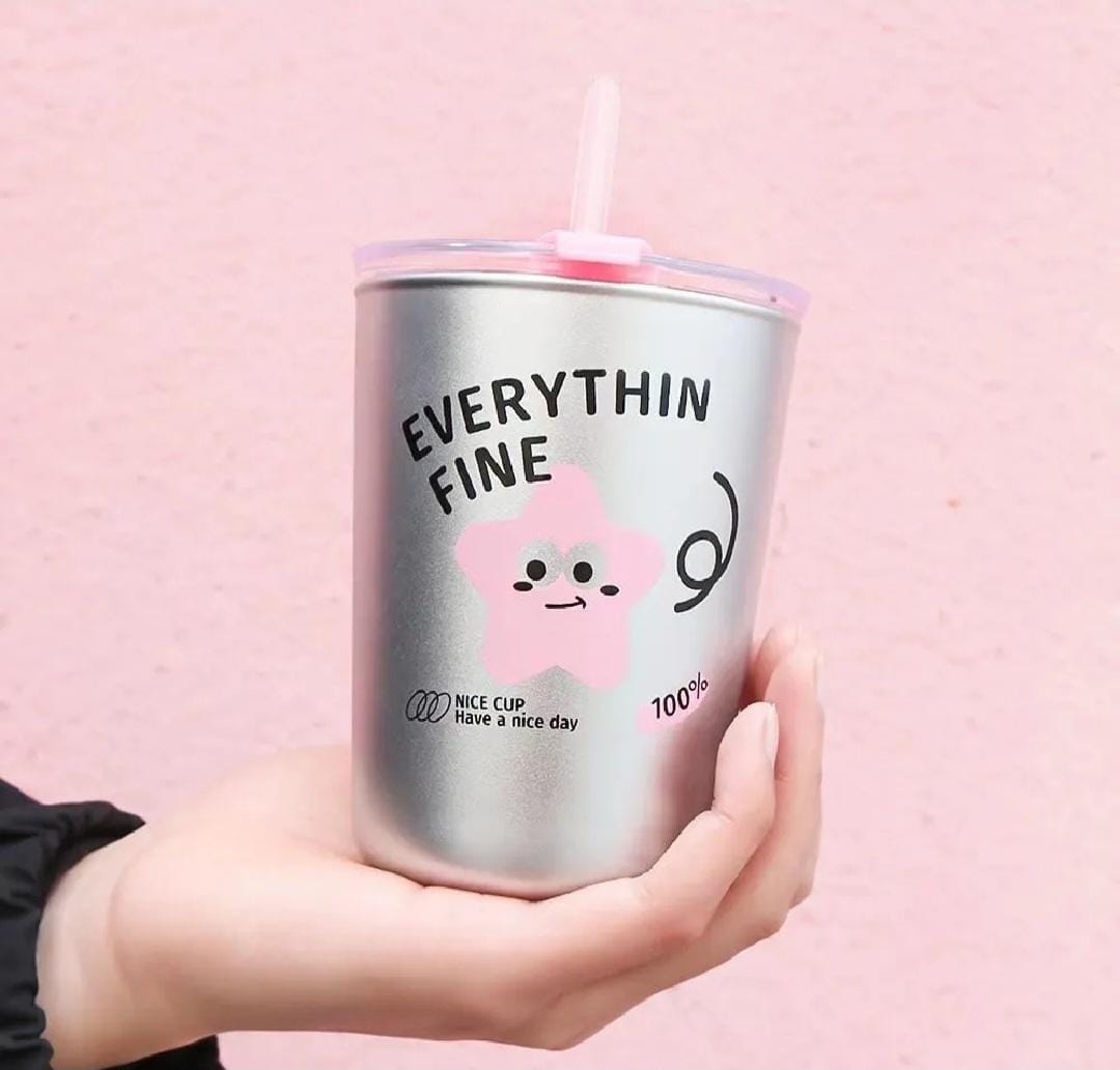 A hand holding a metallic silver tumbler with a pink lid and straw. The cup features a cute pink cartoon star character and the text 'EVERYTHING FINE' in black.